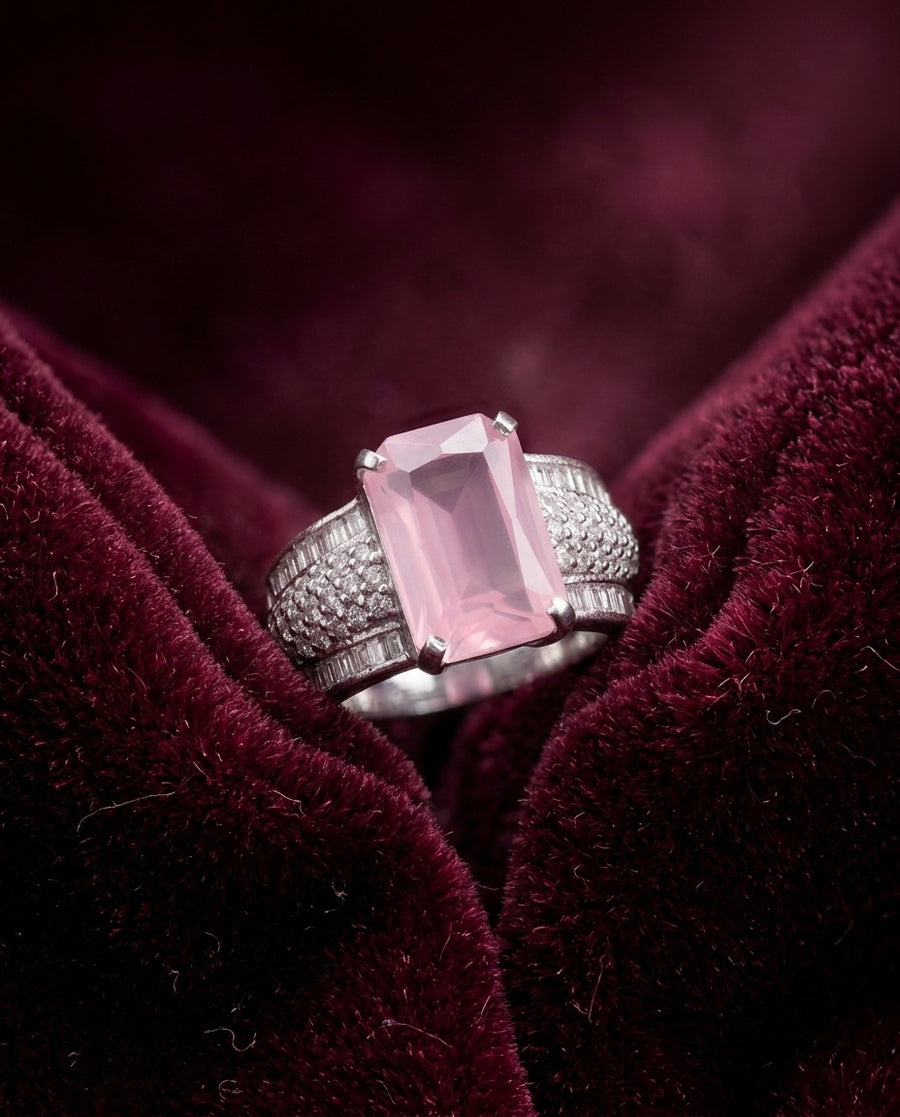 A pink stone silver ring on deep red velvet